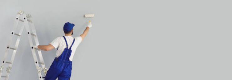 A Professional Painter Painting Interior Wall With Paint Roller